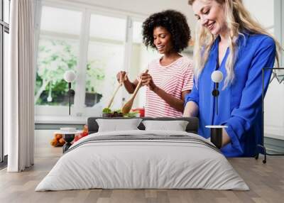 cheerful female friends preparing food at table Wall mural