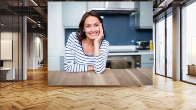 cheerful young woman sitting at table Wall mural