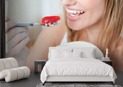 Close-up of a woman eating muesli with fruits Wall mural