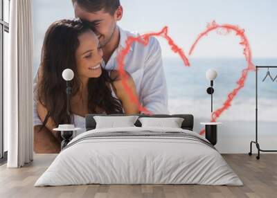 Composite image of attractive couple cuddling Wall mural