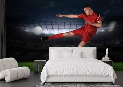 Composite image of fit football player playing and kicking Wall mural