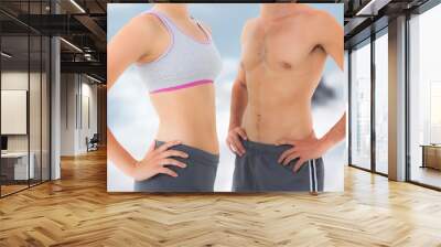 Composite image of mid section of a fit young couple Wall mural