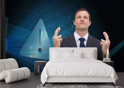 Composite image of serious businessman with fingers crossed is l Wall mural