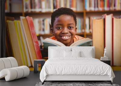 cute african american boy reading book in library Wall mural