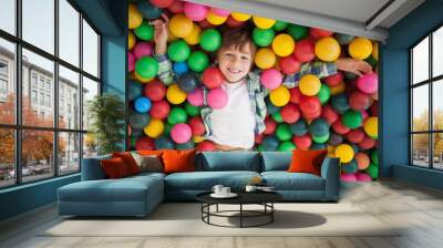 Cute boy smiling in ball pool Wall mural