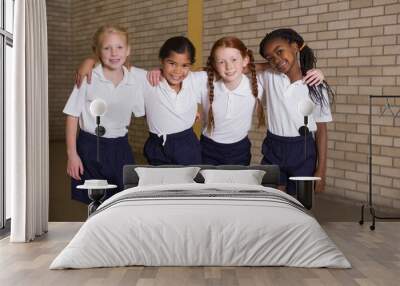 Cute pupils smiling at camera in PE uniform Wall mural