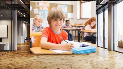 Cute pupils writing at desk in classroom Wall mural