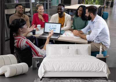 Disabled biracial businesswoman explaining strategy to happy colleagues during meeting Wall mural