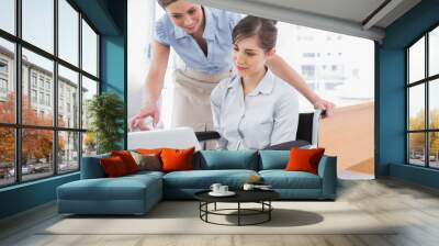 Disabled businesswoman showing co worker her laptop Wall mural