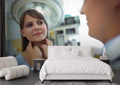 Doctor examining a female patients neck Wall mural