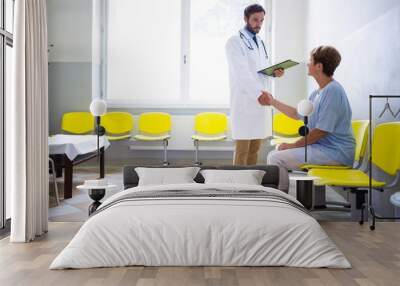 Doctor shaking hand with patient in waiting room Wall mural