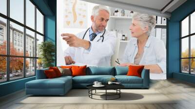 Doctor with female patient reading reports on computer Wall mural