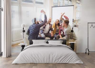 Excited creative business people giving high-five Wall mural