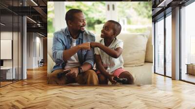 Father and son fist bumping while playing video game Wall mural