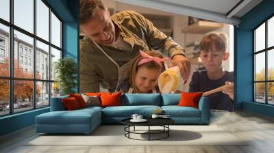 Father with his children preparing food in kitchen Wall mural