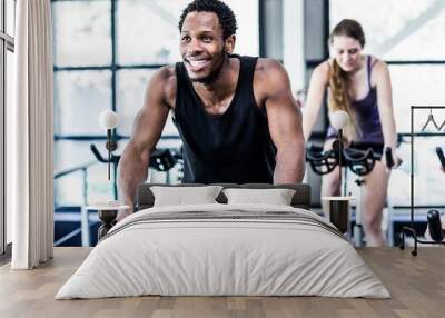 fit man working out at spinning class Wall mural