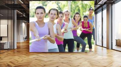 Fitness group playing tug of war Wall mural