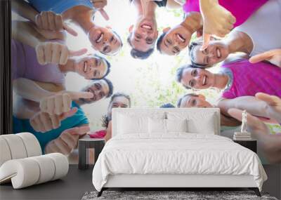 Fitness group smiling at camera in park Wall mural