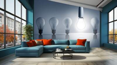 Five light bulbs in a row with one lit up Wall mural