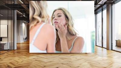 focused beautiful young woman looking at herself in the bathroom Wall mural