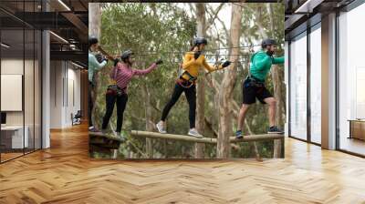 Friends enjoying zip line adventure in park Wall mural