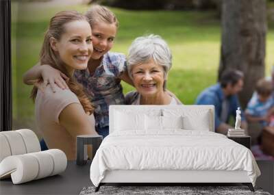 grandmother, mother and daughter with family in background at pa Wall mural