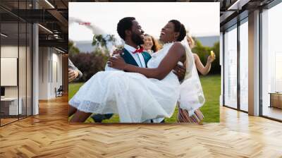 Happy african american couple smiling and carrying during wedding Wall mural