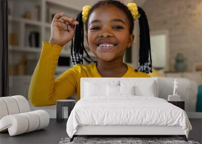 Happy african american girl making video call at home Wall mural