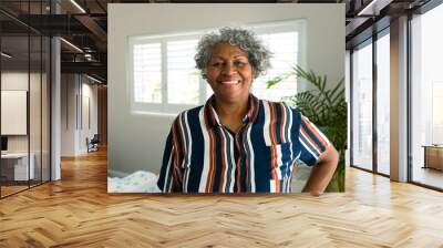 Happy african american senior woman standing in bedroom and looking at camera Wall mural