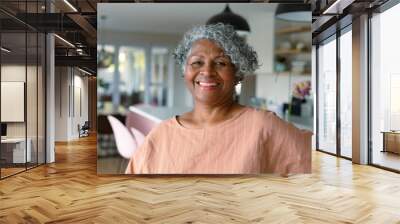 Happy african american senior woman standing standing in kitchen and looking at camera Wall mural