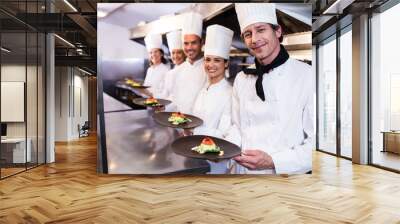 Happy chefs presenting their food plates Wall mural