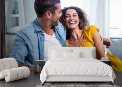 happy couple using a digital tablet on sofa Wall mural