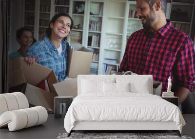 Happy family unpacking cartons together Wall mural