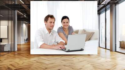 Happy man and woman looking at something on the laptop Wall mural