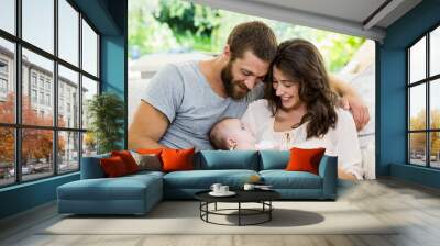 happy parents with their baby in living room Wall mural