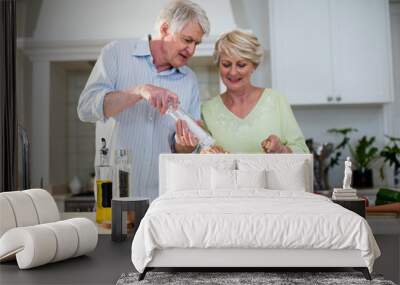 Happy senior couple preparing vegetable salad Wall mural