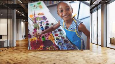 High angle portrait of elementary girl painting at desk Wall mural