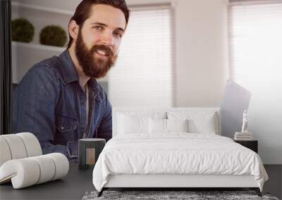 Hipster businessman working at his desk Wall mural