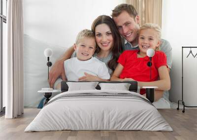 Jolly family using a computer sitting on sofa Wall mural