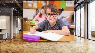 little boy working at his desk in class Wall mural