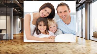 lovely family sitting together on the bed Wall mural