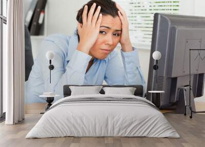 Lovely upset woman looking at a computer screen while sitting Wall mural