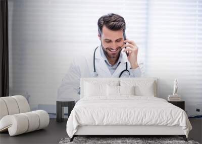 male doctor talking on mobile phone while using digital tablet Wall mural