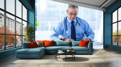 Male doctor writing prescription in hospital Wall mural