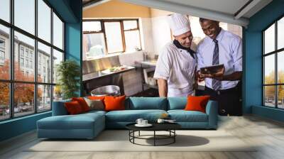 Male manager and chef using digital tablet in kitchen Wall mural