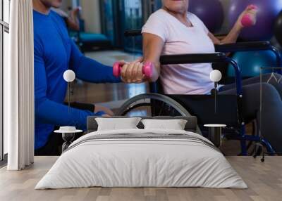 Male physiotherapist helping patient in performing exercise with Wall mural