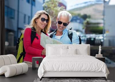 Mature couple reading map in city Wall mural