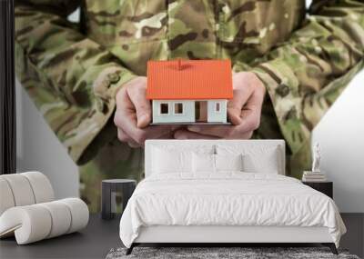 Mid section of soldier holding a model home Wall mural