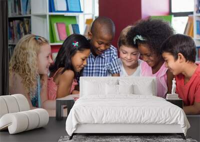 Mixed race children using digital table in library Wall mural