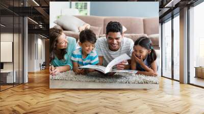 mixed race parents and children lying on rug reading book Wall mural